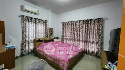 Cozy bedroom with floral curtains and pink bedding, featuring a TV and air conditioning.