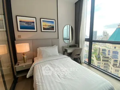 Modern bedroom with city view, featuring sleek furniture and large windows for natural light.