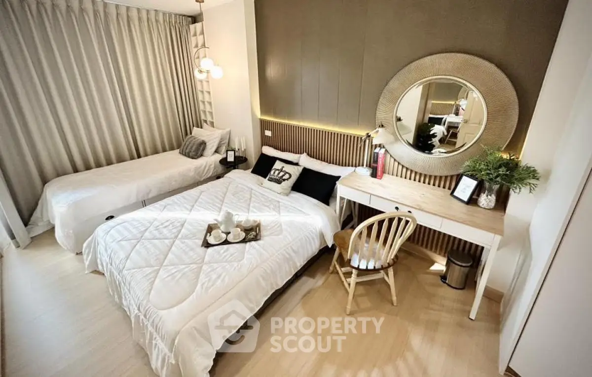 Cozy bedroom with twin beds, elegant decor, and a stylish desk setup.