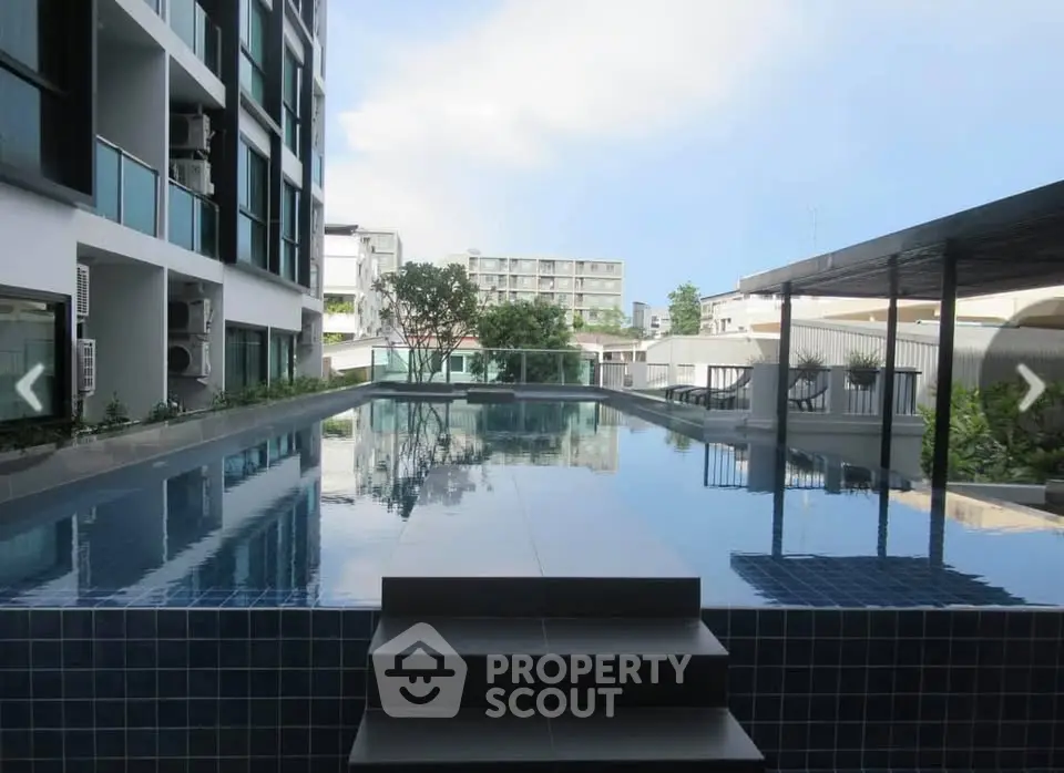 Luxurious modern apartment building with rooftop pool and stunning city views.