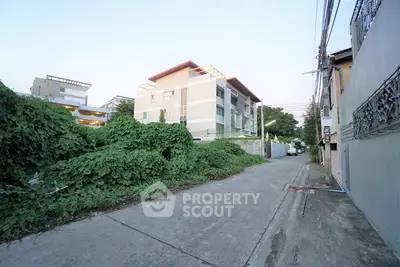 Modern apartment building with lush greenery and quiet street view