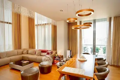 Luxurious modern living room with elegant decor and large windows offering abundant natural light.