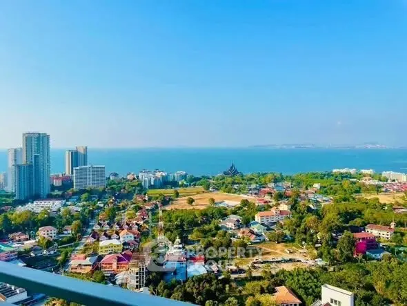 Stunning panoramic city and ocean view from high-rise balcony, showcasing vibrant urban landscape and serene sea horizon.