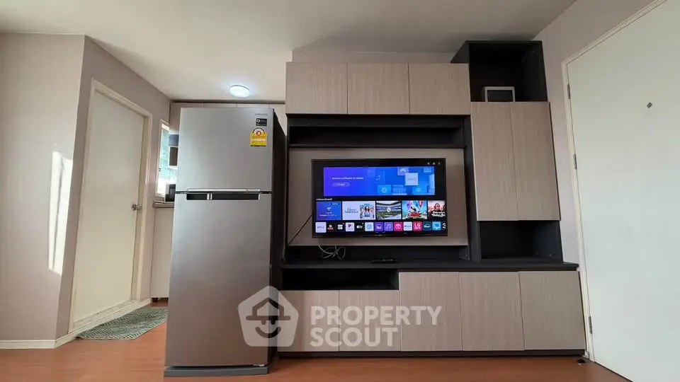 Modern living room with sleek cabinetry and stainless steel fridge