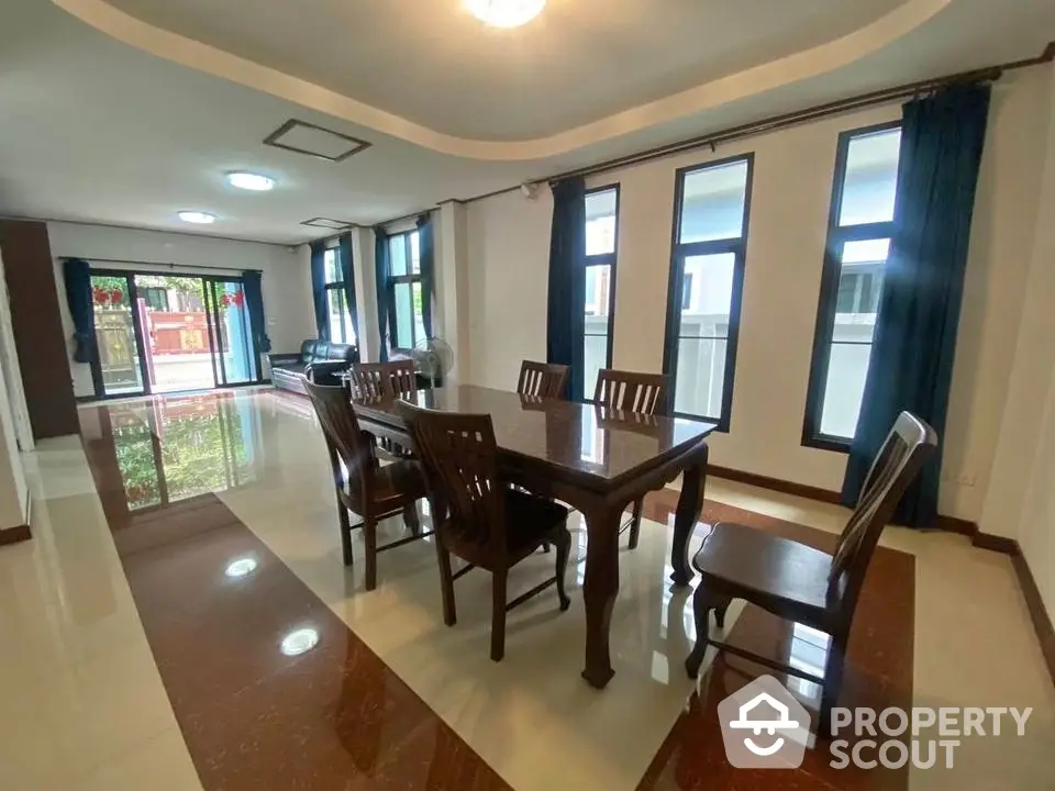 Spacious dining area with elegant wooden furniture and large windows for natural light.