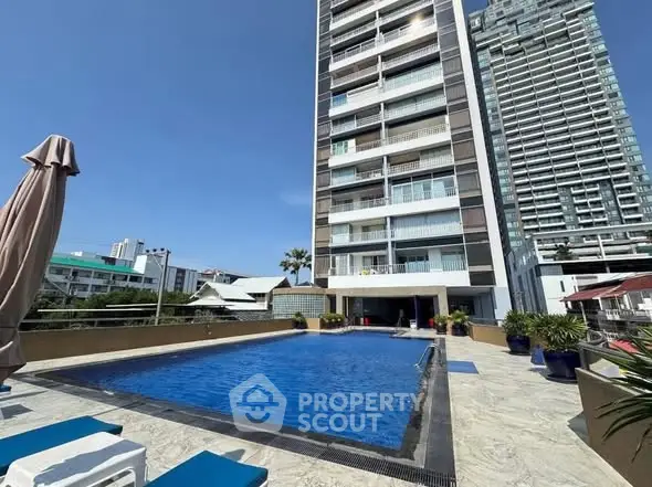 Luxurious high-rise building with a stunning outdoor pool and modern architecture.