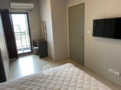 Modern bedroom with balcony access and wall-mounted TV in a stylish apartment.