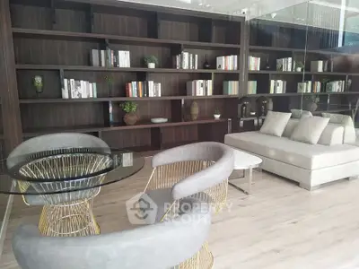 Elegant modern living room with stylish furniture and floor-to-ceiling bookshelves.