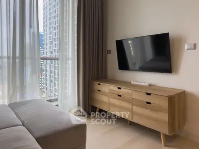 Modern living room with sleek TV setup and city view from balcony.
