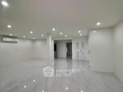 Spacious modern living room with glossy marble flooring and recessed lighting