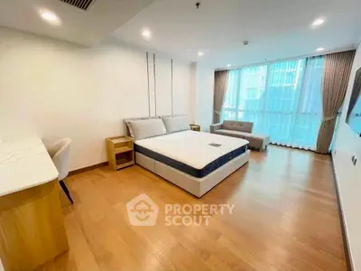 Spacious modern bedroom with large windows and wooden flooring in a luxury apartment.