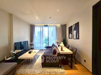 Modern living room with stylish decor, large window, and cozy seating area.