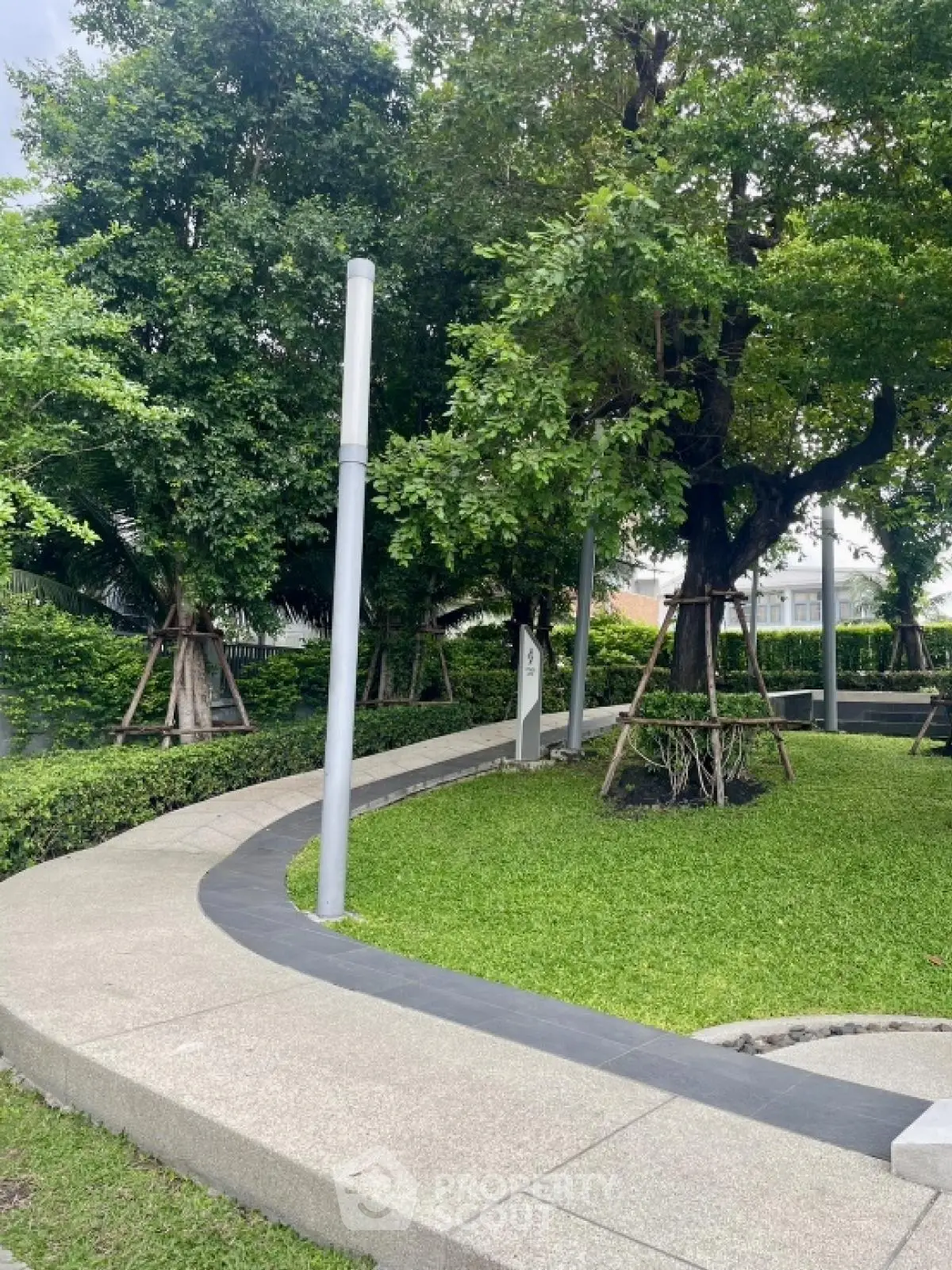 Lush green garden with paved walkway in modern residential complex