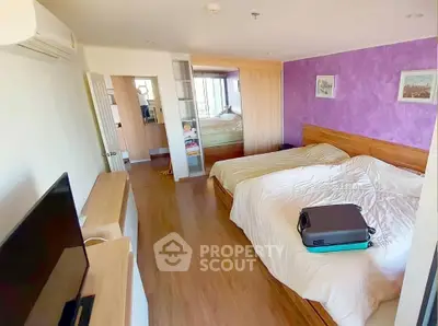 Spacious bedroom with modern decor and wooden flooring, featuring a cozy double bed and ample natural light.