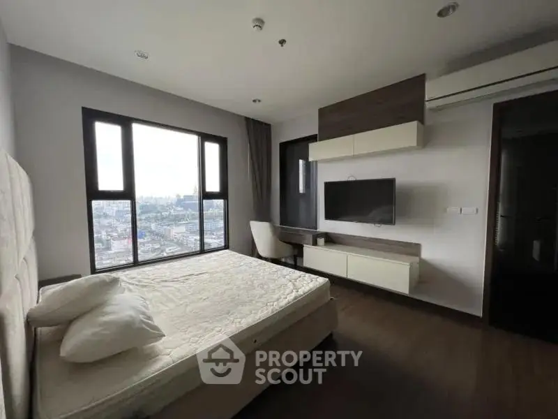Modern bedroom with city view, featuring a sleek design and large windows for natural light.