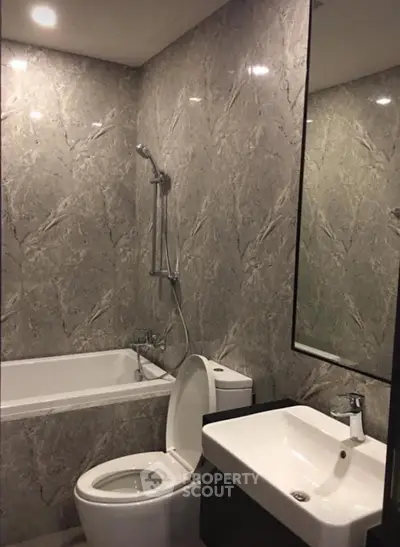 Luxurious marble bathroom with bathtub and modern fixtures, perfect for relaxation and comfort.