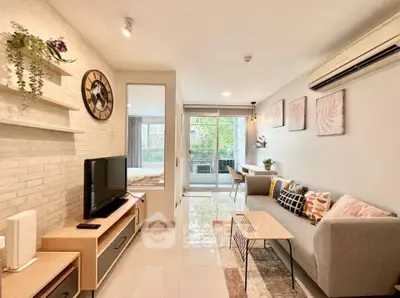 Modern living room with stylish decor and open layout leading to a cozy bedroom.