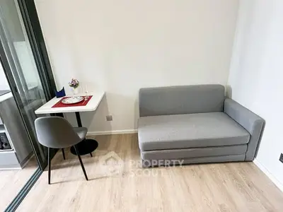 Cozy modern living room with gray sofa and dining table in compact apartment.