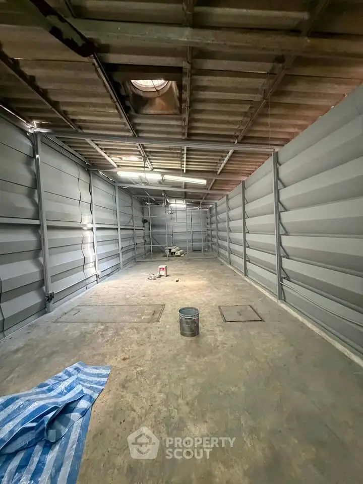 Spacious industrial storage unit with high ceilings and metal walls, ideal for warehousing needs.