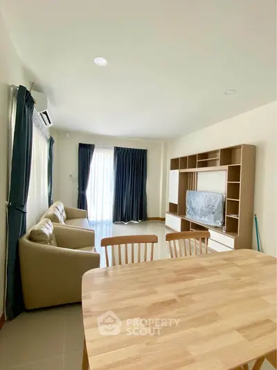 Spacious living room with modern furniture and natural light, perfect for relaxation and entertainment.
