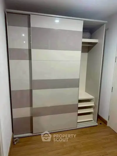 Modern built-in wardrobe with sliding doors and shelving in a stylish bedroom.