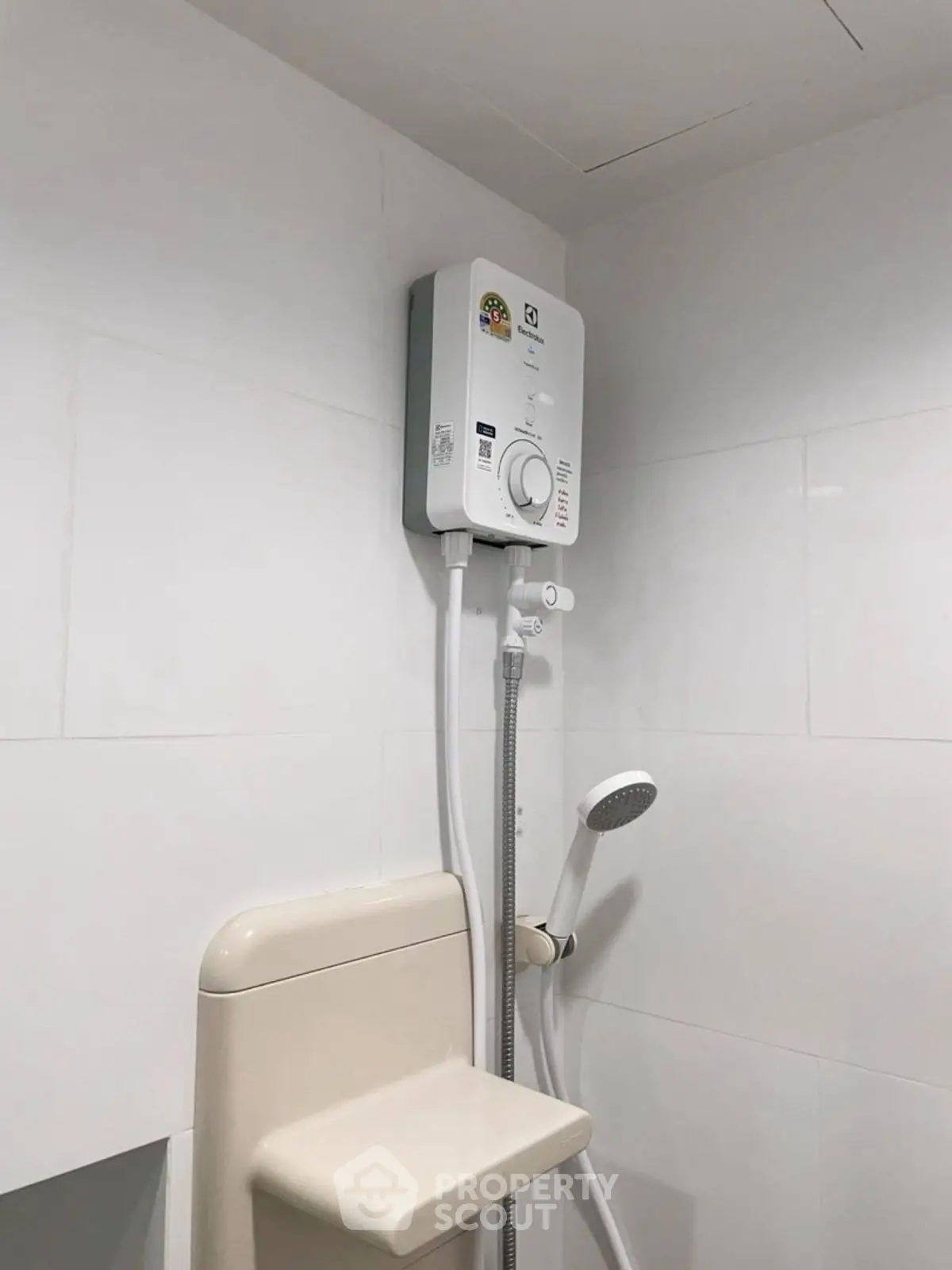 Modern bathroom with sleek white tiles and a compact water heater.