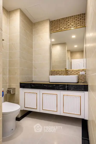 Modern bathroom with elegant vanity and large mirror in a stylish real estate property.