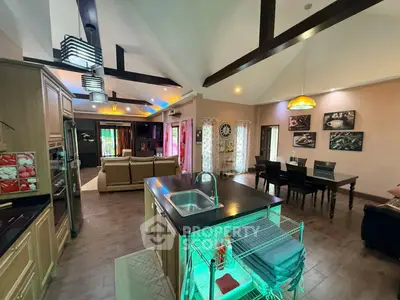 Spacious open-plan living and dining area with modern kitchen island and high ceilings.