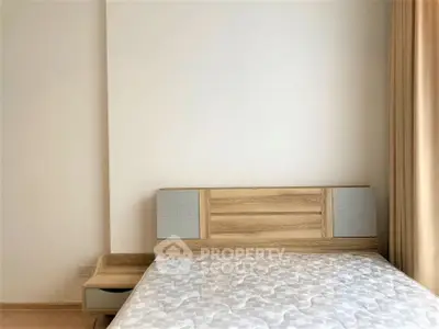 Modern minimalist bedroom with wooden bed frame and neutral decor.