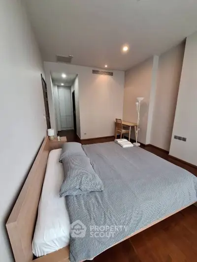 Spacious modern bedroom with minimalist decor and wooden flooring