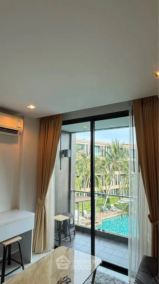 Modern living room with pool view and balcony access in luxury apartment.