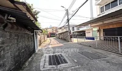 Charming residential alleyway with gated entrance and urban surroundings.