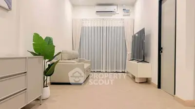 Modern living room with sleek furniture and large TV, perfect for relaxation.