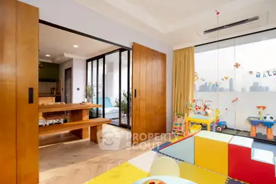 Spacious family-friendly living area with play zone and city view balcony.