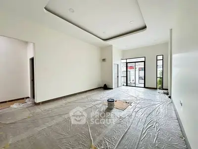 Spacious unfurnished living room with large windows and modern ceiling design.