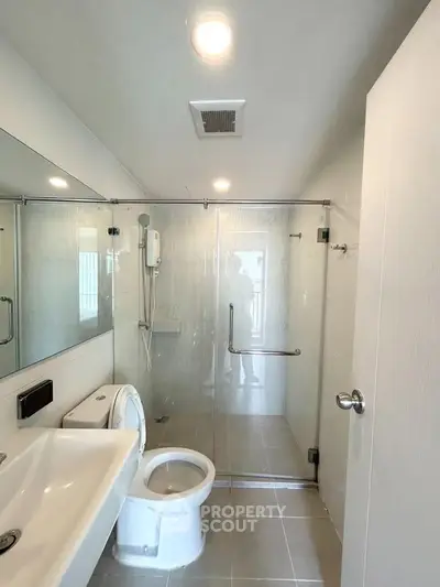 Modern bathroom with glass shower enclosure and sleek fixtures