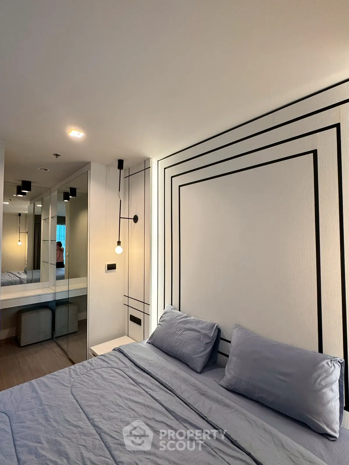 Modern bedroom with stylish decor and cozy bedding in a contemporary apartment.