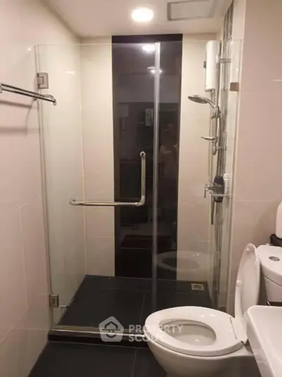 Modern bathroom with glass shower enclosure and sleek fixtures.