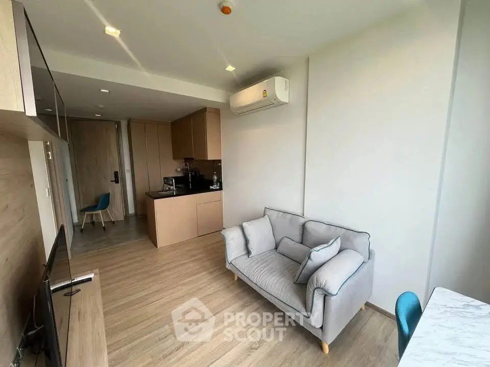 Modern living room with cozy sofa and compact kitchen in open layout apartment