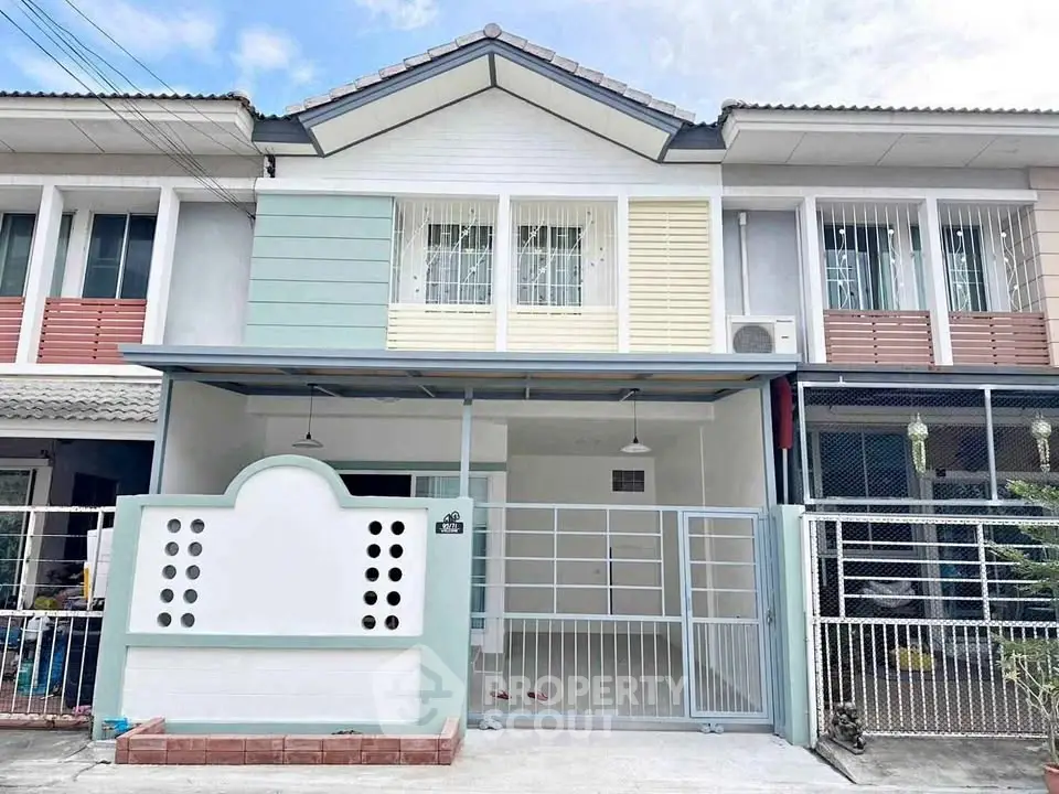 Charming two-story townhouse with gated entrance and modern facade in a serene neighborhood.