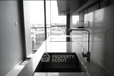 Modern kitchen with sleek design and city view from balcony