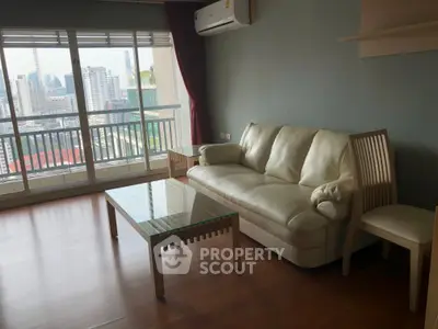 Spacious living room with city view, featuring a comfortable sofa and modern decor.