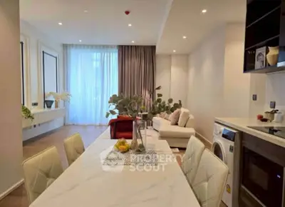 Modern open-plan living room with dining area and washing machine, elegant decor and natural light.