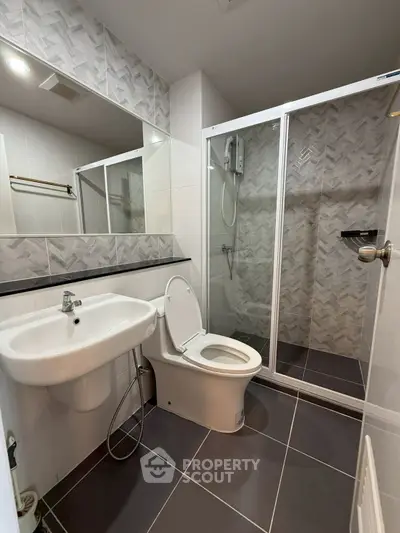 Modern bathroom with sleek design, featuring a shower enclosure and stylish tiling.