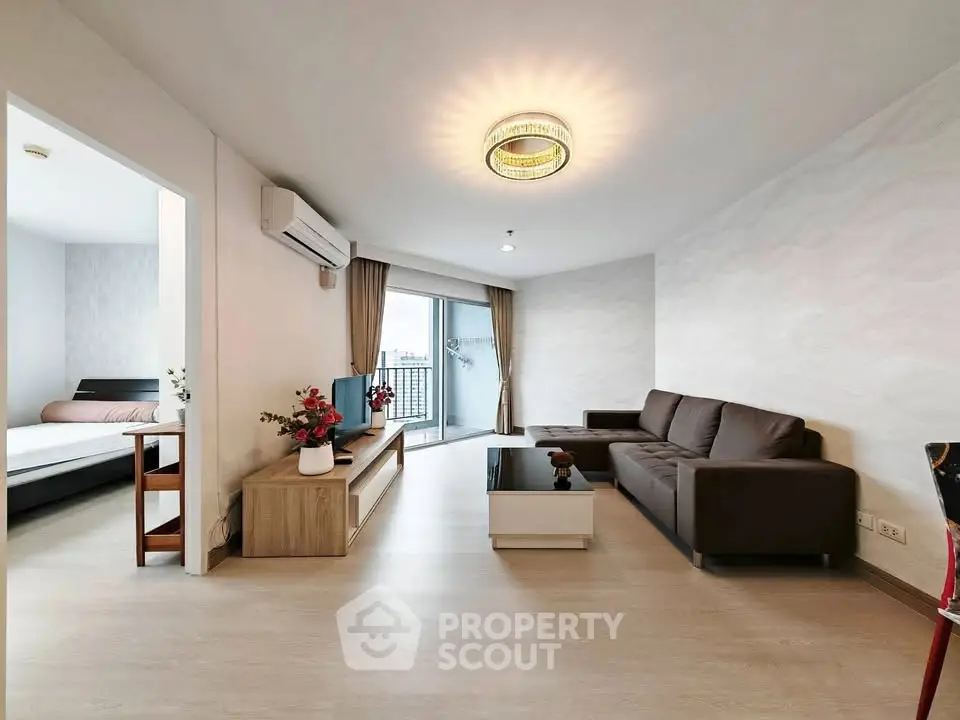 Spacious modern living room with elegant decor and balcony access in a stylish apartment.