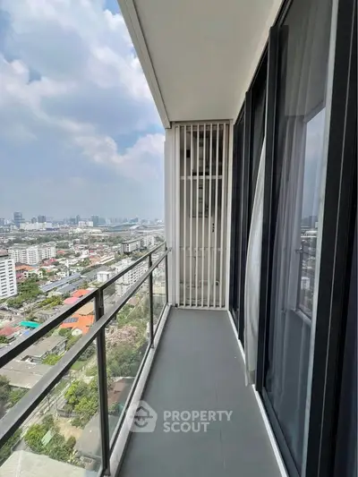 Spacious balcony with stunning city view in modern high-rise apartment.