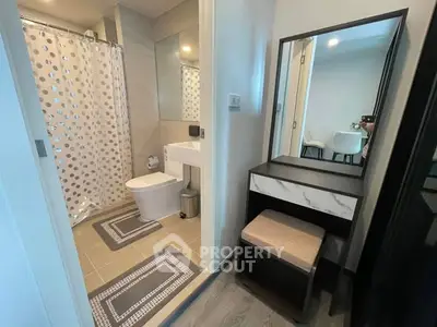 Modern bathroom with stylish vanity and shower curtain in contemporary apartment.