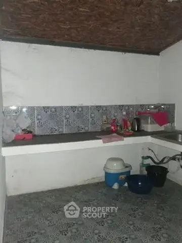 Cozy kitchen with tiled backsplash and essential appliances in a compact layout.