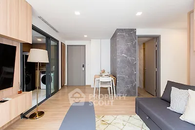 Modern living room with open layout, stylish decor, and natural light, featuring a cozy seating area and dining space.