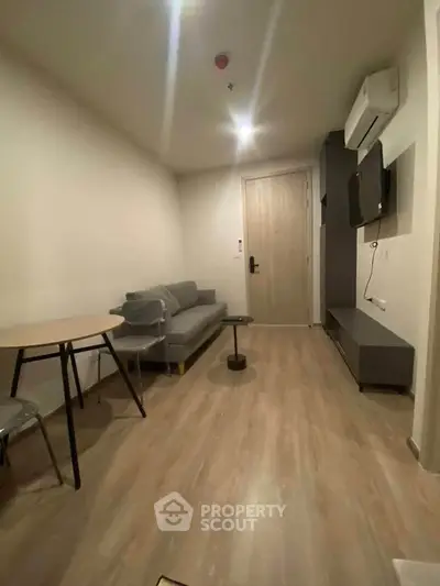 Modern living room with sleek furniture and wooden flooring in a cozy apartment.